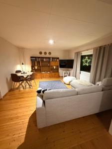 a living room with a white couch and a table at Holiday home on the edge of the woods in Kemijärvi