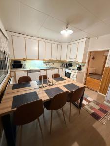 a kitchen with a wooden table and chairs in it at Holiday home on the edge of the woods in Kemijärvi