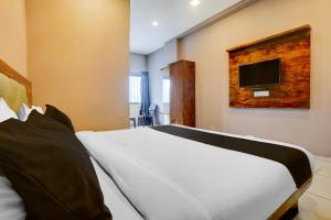 a bedroom with a bed with a tv on the wall at Hotel O Maharashtra Darbar Gonde in Pādli