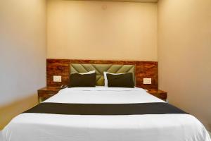 a bedroom with a large white bed with two pillows at Hotel O Maharashtra Darbar Gonde in Pādli +25 photos