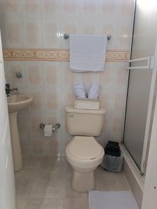 a bathroom with a toilet and a sink and towels at Apto San José in Armenia