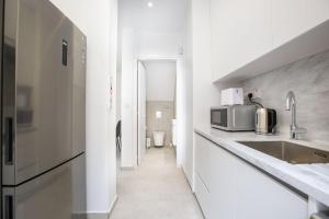 a white kitchen with a sink and a microwave at Two Bedroom House In Town Center by Sweet Keys in Limassol