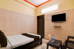 ein Schlafzimmer mit einem Bett und einem Fernseher an der Wand in der Unterkunft Hotel O D Stay Inn in Rushikonda