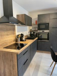 a kitchen with stainless steel appliances and wooden counter tops at Appartement Haut de Gamme neuf avec deux terrasses - 6 personnes - App 102 in Saint-Sorlin-dʼArves +9 photos