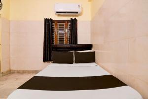 ein kleines Bett in einem Zimmer mit Fenster in der Unterkunft Hotel O D Stay Inn in Rushikonda