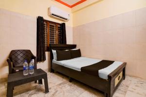 ein Schlafzimmer mit einem Bett, einem Stuhl und einem Tisch in der Unterkunft Hotel O D Stay Inn in Rushikonda