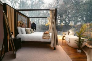 ein Schlafzimmer mit einem Bett und einer Badewanne und einem Fenster in der Unterkunft Cromore Retreat in Portstewart