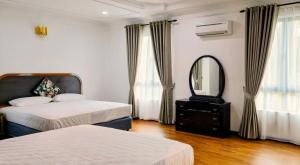 a bedroom with two beds and a mirror and a dresser at Gasing WheelHouse in Petaling Jaya +12 photos