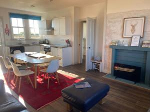 une cuisine et un salon avec une table et des chaises dans l'établissement Mick's Cottage, à Crail