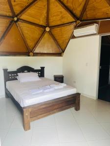 a bedroom with a large bed with a wooden ceiling at Casa Hotel La Esperanza in Orito