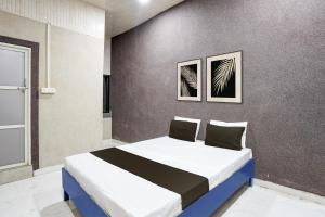 a bedroom with a bed with two pictures on the wall at Hotel O The Lotas Gardan in Sipra