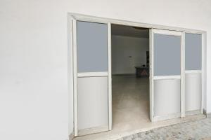a sliding glass door in a white room at SPOT ON Gorav Smark in Malhour