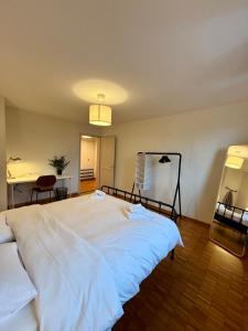 a large white bed in a room with a table at Live Zurich in Cozy Apartment in Zürich