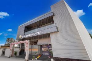 a building with a sign that reads sand hotel at SPOT ON G Grand Hotel in Narela +22 photos