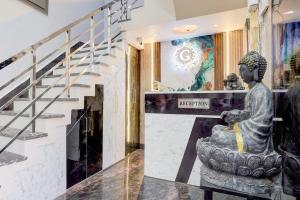a statue in a lobby next to a staircase at SPOT ON G Grand Hotel in Narela