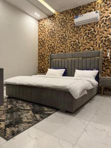 a bedroom with a bed and a wall with a heater at Cozy 3BR Entire Home In DHA Rahbar Lahore in Lahore