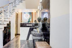 a statue of two people sitting in a chair in a room at SPOT ON G Grand Hotel in Narela