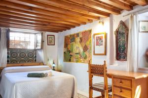 a bedroom with two beds and a desk and a window at Oripando Private Rooms in Granada