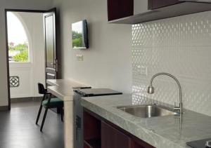 una cocina con fregadero y encimera en Naungan Intaran Mandala, en Sanur