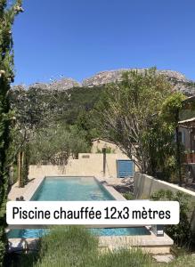 - une piscine dans une cour avec une montagne en arrière-plan dans l'établissement Chambres & Table d'Hôtes Au Soleil du Bonheur, à Lafare