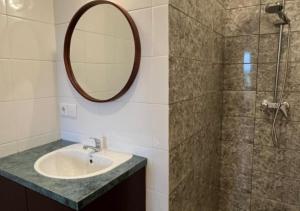 Un baño con lavabo y ducha con espejo. en Naungan Intaran Mandala, en Sanur 11 fotos más