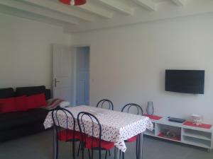 een woonkamer met een tafel met stoelen en een bank bij Charmant appartement à Ainhoa in Aïnhoa