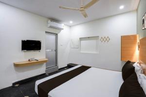 a bedroom with a bed and a tv on the wall at Hotel O The Bell Woods in Mūrhīpār