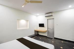 a white room with a desk and a refrigerator at Hotel O The Bell Woods in Mūrhīpār +23 photos