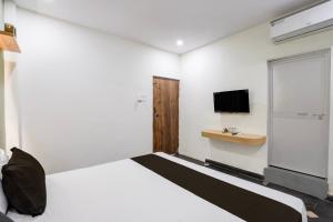 a white room with a bed and a tv at Hotel O The Bell Woods in Mūrhīpār