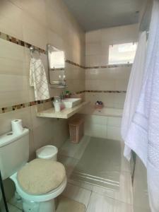 a bathroom with a toilet and a sink at Grande casa para COP30 perto do parque da cidade in Belém