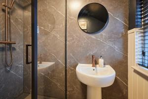 een badkamer met wastafel en douche met spiegel bij Host & Stay - Daisy Cottage in Masham