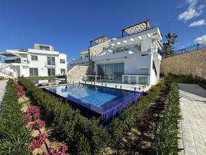 una villa con piscina frente a una casa en Poseidon North Ciprus, Tatlisu, 