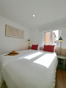 a bedroom with a large white bed with red pillows at Apartamento Vista Mar -Marzaré in Nazaré
