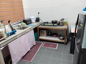 a small kitchen with a sink and a stove at Homestay No 68 Raub in Raub +6 photos