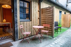 ein Tisch und vier Stühle neben einem Gebäude in der Unterkunft TyKalon Duplex en plein cœur historique de Dinan in La Celle-sous-Gouzon
