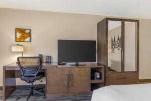a bedroom with a desk with a television and a chair at Best Western Plus McCall Lodge and Suites in McCall