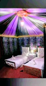a room with two beds with lights on the wall at Wadi Rum Camp &Tours in Wadi Rum