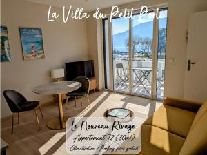 a living room with a table and chairs and a balcony at LA VILLA DU PETIT PORT - Appartements & chambres in Aix-les-Bains