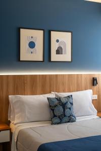1 dormitorio con una pared azul y 2 cuadros encima de una cama en Majhu Hostal, en Tacna 26 fotos más