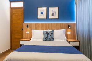 a bedroom with a bed with a blue wall at Majhu Hostal in Tacna