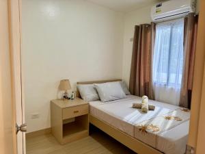 a small bedroom with a bed and a window at Rose Inn in Mambajao