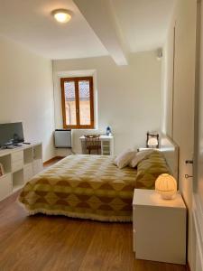 a bedroom with a bed and a table and a television at Teatro Inn - Timeless Charm in Correggio