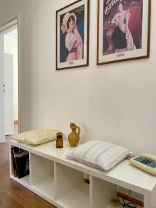 a white table with two framed pictures on a wall at Teatro Inn - Timeless Charm in Correggio