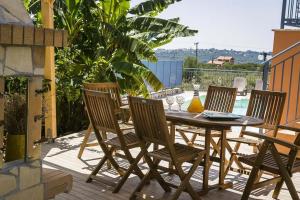 a wooden table and chairs on a patio at Villa Xenia in Karavadhos
