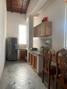 a kitchen with a refrigerator and a table and chairs at Villa Unawatuna in Unawatuna +12 photos