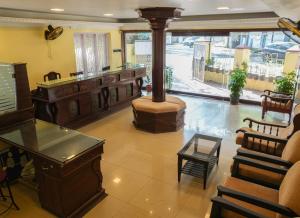 a lobby with a fireplace and a barber shop at Casa Linda in Cochin