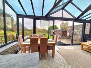 een eetkamer met een tafel en een aantal ramen bij Winster Cottage, Meathop, Grange-Over-Sands in Grange Over Sands