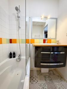 Un baño con bañera, lavabo y espejo. en Molinski, en La Rochelle 14 fotos más