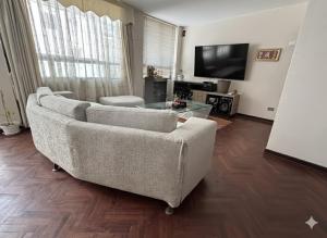 a living room with a couch and a tv at Hostel Wayra Wasi in Lima