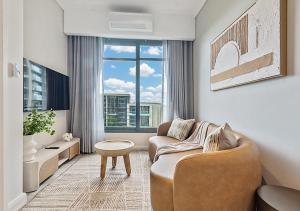 a living room with a couch and a large window at MNM Luxury Suit 424A in Pretoria